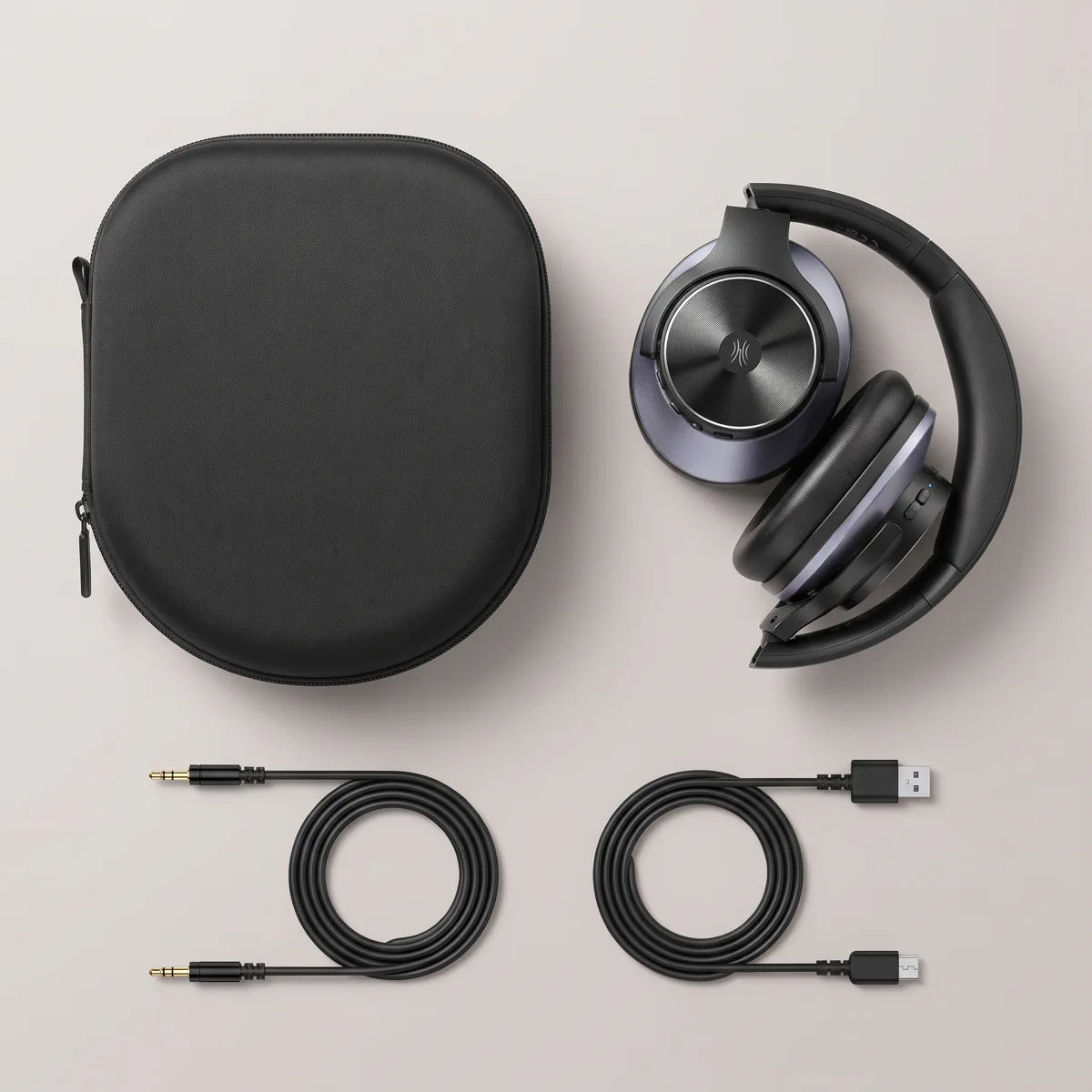 Headphones folded next to the hard case, 3.5 mm cable and USB-C cable