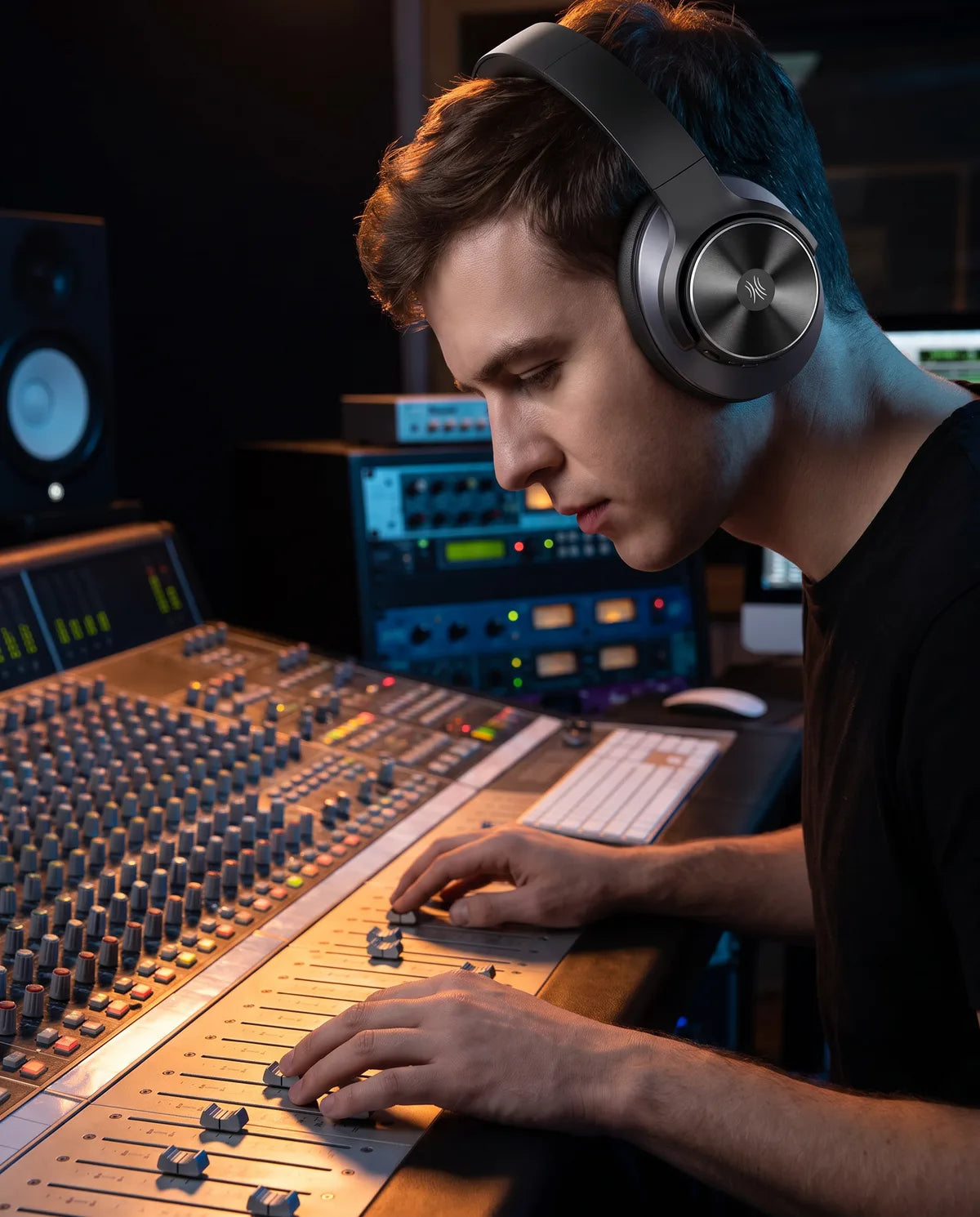 Producer at a mixing desk wearing the headphones